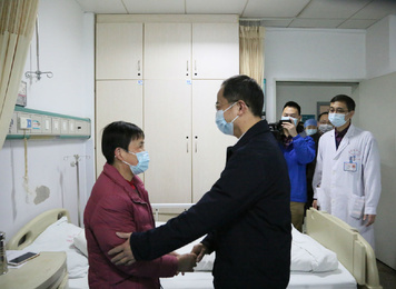 2020年3月3日，福建医科大学党委书记何明华（右）一行来到病房亲切探望援鄂医疗队员住院家属